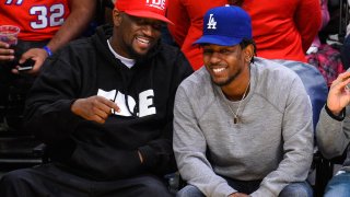 Anthony Tiffith, left, and Kendrick Lamar sit courtside at a basketball game between the Los Angeles Clippers and the Los Angeles Lakers at Staples Center on April 5, 2015.