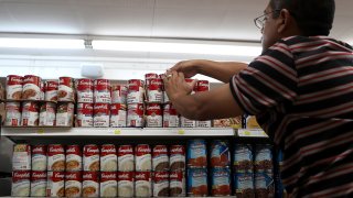 In this file photo, a worker arranges cans of Campbell's soup on a supermarket shelf on May 20, 2016 in San Rafael, California.