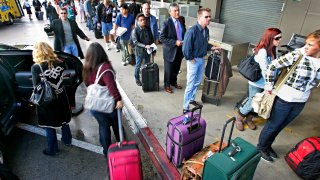 Thanksgiving travelers wait in the security line at Terminal 1 at LAX