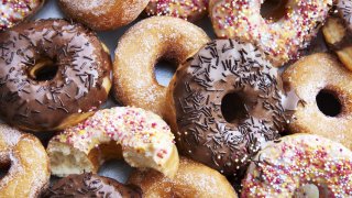 A mixture of iced chocolate and regular ring doughnuts.