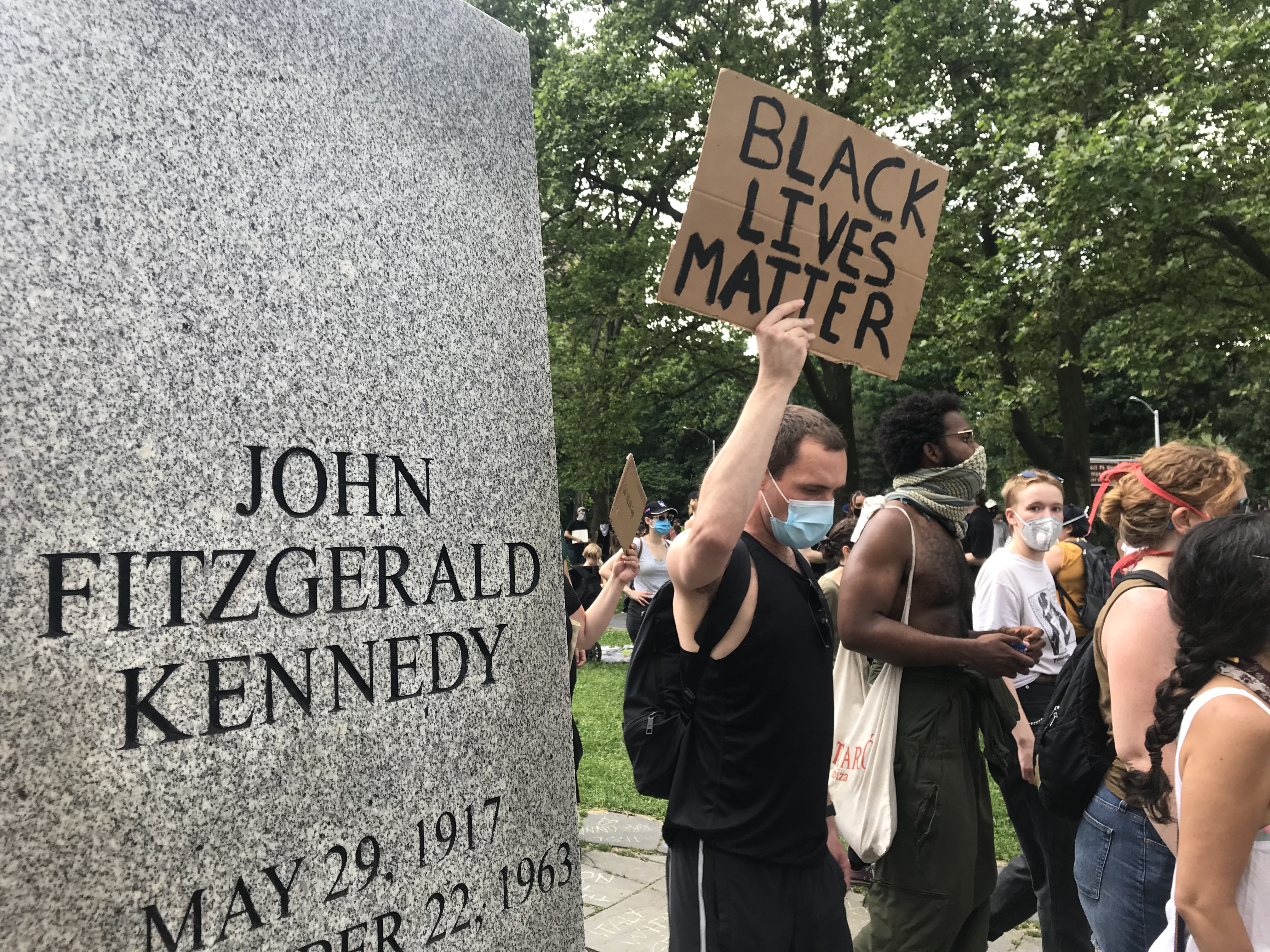 Protesters march past a statue of President John F. Kennedy in Brooklyn, New York on June 6, 2020