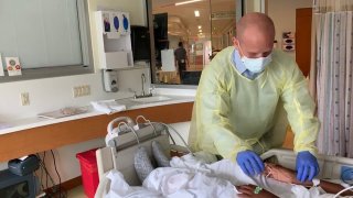 Dr. James Schneider checks pulse of a patient