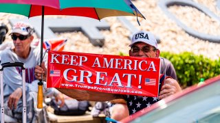 A person holds a sign that reads "Keep America Great!" outside of the BOK Center ahead of a Trump campaign rally in Tulsa, Okla., June 17, 2020. Trump's resumption of his signature campaign rallies this week is intensifying criticism of his response to the biggest domestic crises of his presidency: the deadly coronavirus pandemic and widening protests over police brutality against Black Americans.