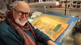 In this file photo taken Sunday Dec. 1, 2013, Tomie DePaola poses with his artwork in his studio in New London, N.H.
