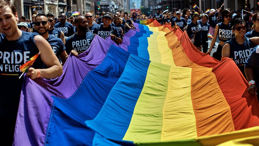 在这张2018年6月24日的文件照片中，狂欢者在纽约市骄傲大游行期间沿着第五大道举着彩虹旗。2019年6月28日是石墙起义50周年纪念日，石墙起义为全球LGBTQ运动点燃了火种。(美联社图片/Andres Kudacki，档案)(photo:NBCLA)