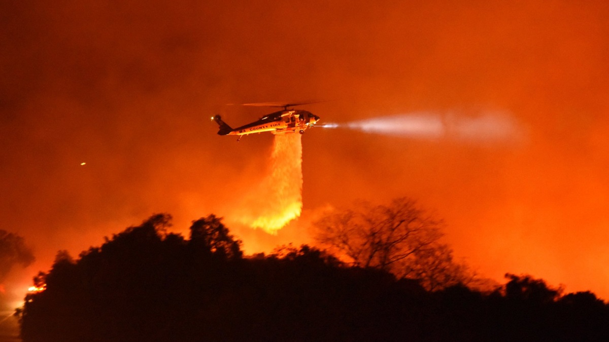 A helicopter performs a water drop on the "Cave Fire" in Santa Barbara County on Monday, Nov. 25, 2019.