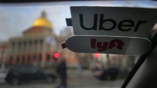 BOSTON, MA – NOVEMBER 14: Uber and Lyft stickers are pictured inside a ride share vehicle outside the Massachusetts State House in Boston on Nov. 14, 2019. Many drivers pick up fares for both companies. That boxy delivery truck blocking your lane is just one maddening manifestation of a public failure to adapt to the new convenience economy. The technology built around our desire for instant gratification – Uber and Lyft, DoorDash and Grubhub, the Amazon packages whizzing from distribution centers to our doorsteps – has become the source of huge amounts of new traffic. Hundreds of thousands of these trips would never have happened just a few years ago. But the public policy response has been no match for this challenge, the Globe Spotlight Team has found. In Boston, in fact, the operative policy only enables the offender. It is part of a pattern of delayed or passive public response to our slow-moving crisis in commuting. True, state officials were a nose ahead of the pack in imposing a surcharge on Uber and Lyft rides three years ago – an attempt at the time to make the companies pay their share of transportation costs – but now they have fallen out of the vanguard. Confronted by the powerful ride-share lobby on Beacon Hill, state leaders havent summoned the will or nerve to impose the kind of high fees and stringent limits other cities are using to try to curb the traffic. (Photo by Lane Turner/The Boston Globe via Getty Images)