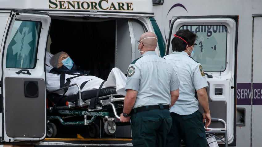 A patient is loaded into the back of an ambulance by medical personnel amid the coronavirus pandemic, Tuesday, April 28, 2020, outside NYU Langone Medical Center in New York.