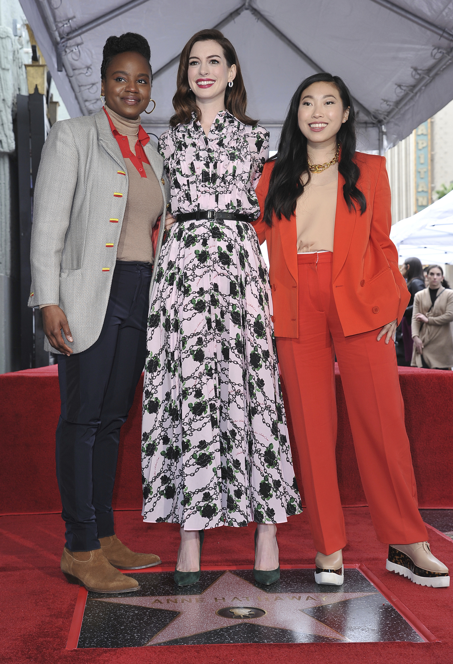 Actress Anne Hathaway, center, writer/director Dee Rees, left, and actress Awkwafina, right, pose atop Hathaway's new star on the Hollywood Walk of Fame following a ceremony on Thursday, May 9, 2019, in Los Angeles. (Photo by Richard Shotwell/Invision/AP)