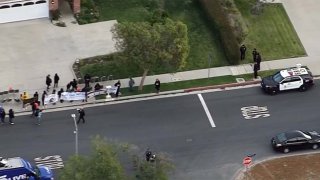 Protesters hold banners outside the Granada Hills home of Los Angeles County District Attorney Jackie Lacey.