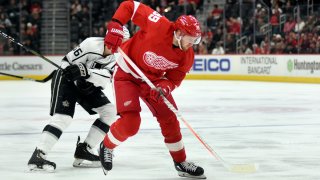 Detroit Red Wings right wing Anthony Mantha, right, skates with the puck past Los Angeles Kings defenseman Kurtis MacDermid in the third period of an NHL hockey game Sunday, Dec. 15, 2019, in Detroit. The Kings defeated the Red Wings 4-2.