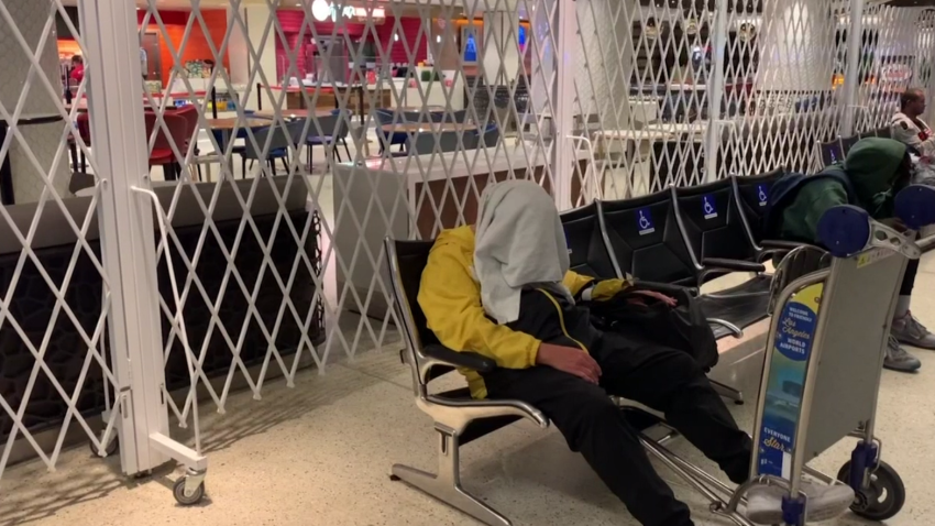 homeless man sleeps on chair at Los Angeles International Airport