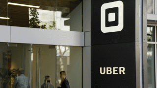 In this June 21, 2017, file photo, people make their way into the building that houses the headquarters of Uber in San Francisco.