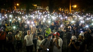 Demonstrators raise their cell phone lights as they chant slogans during a Black Lives Matter protest at the Mark O. Hatfield United States Courthouse Wednesday, July 29, 2020, in Portland, Ore.