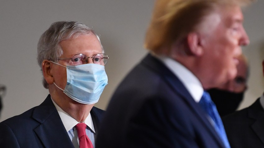 Senate Majority Leader Mitch McConnell, a Republican from Kentucky, wears a protective mask as U.S. President Donald Trump speaks to members of the media following the weekly Senate Republican caucus luncheon at the Hart Senate Office Building in Washington, D.C., U.S., on Tuesday, May 19, 2020. Trump threatened to withdraw altogether from the World Health Organization, a move that would leave Chinese leader Xi Jinping as the most prominent voice leading the global fight against the pandemic.