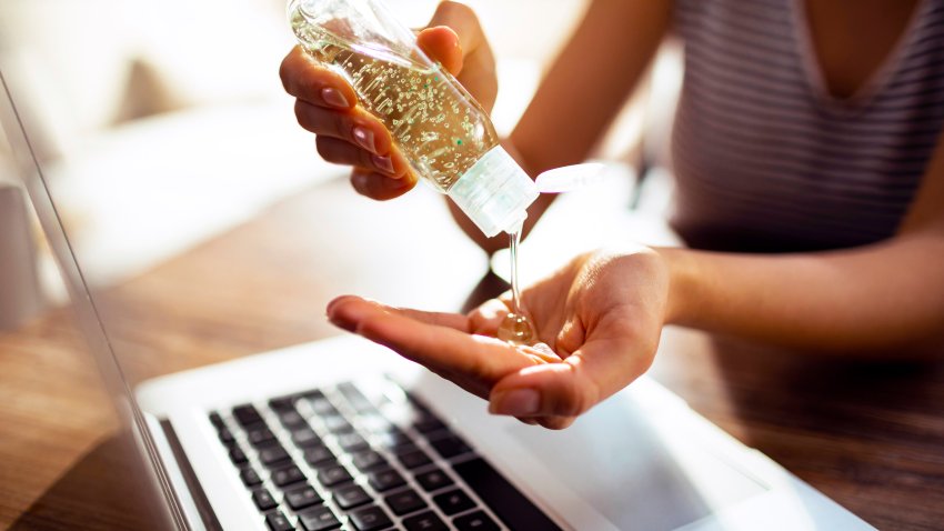 Young woman using a hand sanitizer