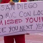 A cosplayer holds up a sign with a message for out-of-towners unable to show their love for Comic-Con International in person due to the coronavirus pandemic.