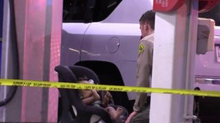 A sheriff's department deputy plays with a toddler whose mother was shot.