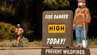Smokey Bear wears a protective face mask as he warns of High Fire Danger at the Riverside Drive and Los Feliz Blvd entrance to Griffith Park in Los Angeles Tuesday, May 26, 2020 as the Southland’s latest heat wave will send the mercury soaring into triple-digit territory raising the risk of heat-related illnesses.