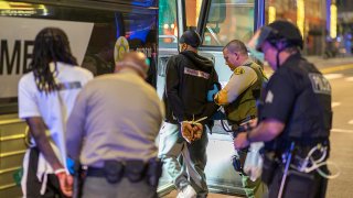 Arrestees are loaded onto a sheriff's bus to be taken to jail as large numbers of people are arrested after a curfew went into effect during demonstrations over the death of George Floyd.