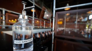 A bottle of hand sanitizer is seen at the hostess stand of Bad Daddy's Burger Bar as it reopened for dine-in seating
