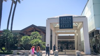Shoppers enter South Coast Plaza Monday, which will be closed down Tuesday for a second time by Gov. Newsom in an attempt to slow the spread of coronavirus on Monday, July 13, 2020 in Costa Mesa, CA.