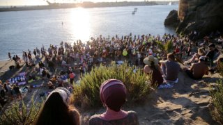 Worshippers gather along the Pacific Ocean at the ‘Saturate OC’ beach revival held amid the COVID-19 pandemic on August 7, 2020 in Newport Beach, California. Hundreds gathered for the last of a series of weekly beach worship services which began July 3rd in defiance of a ban on mass gatherings in Orange County. Many worshippers did not wear masks or practice social distancing amid continued tensions between state officials and some houses of worship over coronavirus restrictions. Co-organizer Parker Green told CBSLA, ‘People are far more afraid of losing their civil liberties in the long run than getting sick’.
