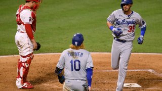 Cody Bellinger #35 of the Los Angeles Dodgers reacts to his two run homerun in front of Max Stassi #33 of the Los Angeles Angels and Justin Turner #10, to take a 4-1 lead over the Los Angeles Angels, during the sixth inning at Angel Stadium of Anaheim on August 14, 2020 in Anaheim, California. (Photo by Harry How/Getty Images)