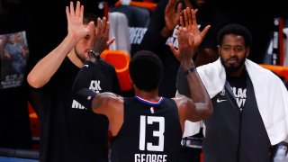 Paul George #13 of the LA Clippers is congratulated by teammates after hitting a three point basket against the Dallas Mavericks during the fourth quarter in Game One of the Western Conference First Round during the 2020 NBA Playoffs at AdventHealth Arena at ESPN Wide World Of Sports Complex on August 17, 2020 in Lake Buena Vista, Florida. (Photo by Kevin C. Cox/Getty Images)