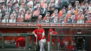 Mike Trout #27 and manager Joe Maddon of the Los Angeles Angels watch the game against the San Francisco Giants from the dugout at Oracle Park on August 20, 2020 in San Francisco, California.
