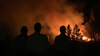 Firefighters looking at flames from the Bobcat Fire.