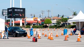 A person drives into a drive-through COVID-19 testing site.