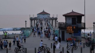 File Image: A sign reminding people to wear their facemasks is seen by the pier during a heat wave on September 7, 2020 in Manhattan Beach, California, amid the coronavirus pandemic.