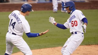 Enrique Hernandez #14 of the Los Angeles Dodgers congratulates Mookie Betts #50 after a home run in the fifth inning at Dodger Stadium on September 13, 2020 in Los Angeles, California. (Photo by John McCoy/Getty Images)
