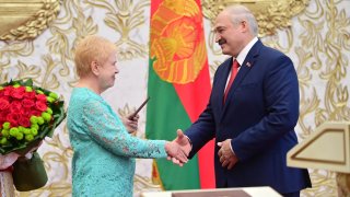 Lidiya Yermoshina (L), Chairperson of the Belarusian Central Election Commission, hands over a presidential ID to Belarus' President-Elect Alexander Lukashenko during his inauguration ceremony at the Palace of Independence on September 23, 2020.