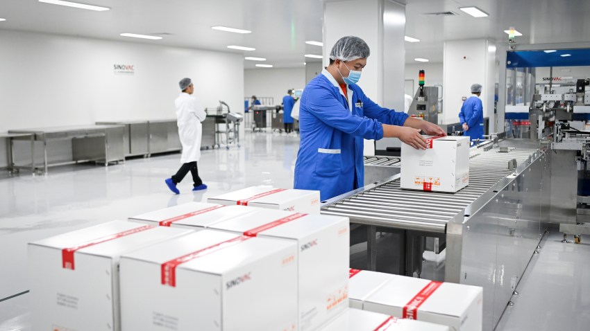 A staff member works during a media tour of a new factory built to produce a COVID-19 coronavirus vaccine at Sinovac, one of 11 Chinese companies approved to carry out clinical trials of potential coronavirus vaccines, in Beijing on September 24, 2020.
