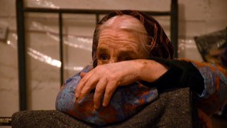 A elderly woman sits on a bed in a building's basement used as a bomb shelter in Nagorny Karabakh's main city of Stepanakert on September 28, 2020.