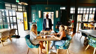 File Image: Amber Tobias, right, and Melody Conour Chat with General Manager Reggie Robinson while eating inside Fable & Spirit about an hour after California Gov. Gavin Newsom announced the immediate resumption of indoor dining for Orange County in Newport Beach, CA, on Tuesday, Sept., 8, 2020.