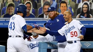 Edwin Rios #43 of the Los Angeles Dodgers celebrates with teammates Justin Turner and Mookie Betts .