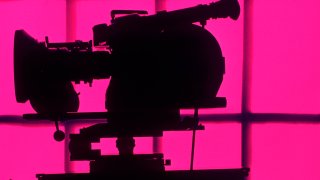 Silhouetted motion picture camera.