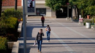 In this Sept. 2, 2020, file photo, people walk on campus at San Diego State University in San Diego.
