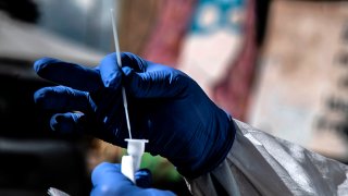 A medical worker prepares for drive-through COVID-19 tests outside the Santa Maria della Pieta' hospital in Rome, Oct. 12, 2020.