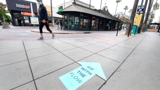 Arrows on the ground point in the direction shoppers are requested to walk abiding by social distancing guidelines.