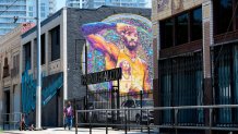 A pedestrian walks past a Kobe and Gianna Bryant mural titled "Salute" by artist Aiseborn on August 24, 2020 in Los Angeles, California. - Two Los Angeles city councilmen, Curren Price and Herb Wesson, plan to introduce a motion calling for a section of Figueroa Street to be named "Kobe Bryant Boulevard", from Staples Center to Exposition Park in honour of Bryant, who died in a helicopter crash with his daughter Gianna and others members of their party on January 26 this year. (Photo by Frederic J. BROWN / AFP) / RESTRICTED TO EDITORIAL USE - MANDATORY MENTION OF THE ARTIST UPON PUBLICATION - TO ILLUSTRATE THE EVENT AS SPECIFIED IN THE CAPTION (Photo by FREDERIC J. BROWN/AFP via Getty Images)