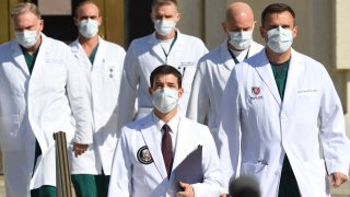 In this Oct. 5, 2020, file photo, White House physician Sean Conley (C) arrives to answer questions surrounded by other doctors, during an update on the condition of US President Donald Trump at Walter Reed Medical Center in Bethesda, Maryland.