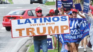 Supporters hold placards after Vice President Mike Pence addressed supporters at a Latinos for Trump campaign rally at Central Christian University on Oct. 10, 2020 in Orlando, Florida. With 24 days until the 2020 presidential election, both Donald Trump and Democrat Joe Biden are courting the Latino vote as Latinos are the largest racial or ethnic minority in the electorate, with 32 million eligible voters.