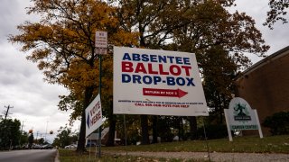 In this Oct. 15, 2020, file photo, a sign directs voters to the absentee ballot drop-box in Detroit, Michigan.
