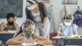 Young female student wearing a protective face mask in the classroom