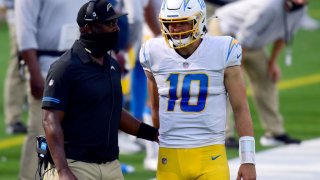 File Image: Justin Herbert #10 and head coach Anthony Lynn of the Los Angeles Chargers talk after a timeout during the fourth quarter at SoFi Stadium on September 27, 2020 in Inglewood, California. (Photo by Harry How/Getty Images)