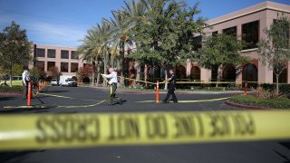 Officers put up police tape in front of the building at the Inland Regional Center where 14 people were killed on Dec. 7, 2015 in San Bernardino.